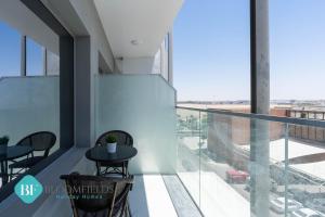 Elegant Studio In Oasis في أبوظبي: شرفة في مبنى مع طاولة وكراسي
