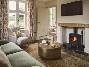 uma sala de estar com um sofá e uma lareira em Bridge House at Woodhall Estate em Hertford