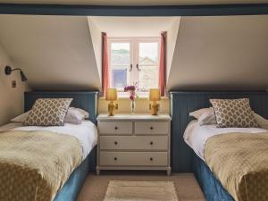 a bedroom with two beds and a window at Bridge House at Woodhall Estate in Hertford