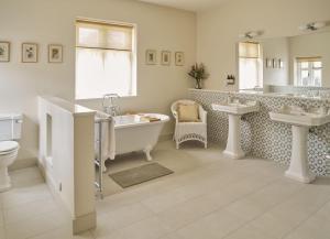 y baño con 2 lavabos, bañera y aseo. en Bridge House at Woodhall Estate en Hertford