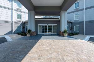 a large building with a courtyard with potted plants at TRYP by Wyndham Tallahassee North I-10 Capital Circle in Tallahassee