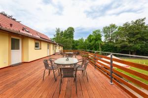 a wooden deck with a table and chairs on it at Apartamenty FILIP w Kudowie-Zdroju in Kudowa-Zdrój