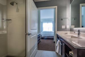 een badkamer met een wastafel, een douche en een bed bij Residence Inn by Marriott Savannah Airport in Savannah