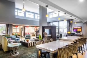 um átrio com mesas e cadeiras e uma sala de estar em Residence Inn by Marriott Savannah Airport em Savannah