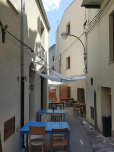 una fila de mesas y sillas azules en un callejón en Baroon Bistrot & Rooms, en Polizzi Generosa