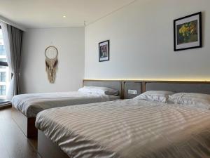 um quarto de hotel com duas camas e um relógio na parede em Apec Mandala Mui Ne R2223 em Ấp Thiẹn Ái