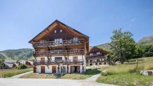 a large wooden house with balconies on a hill at Les Ecureuils B11 - Studio montagne 2 pers in Saint-Sorlin-dʼArves