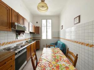 eine Küche mit einem Tisch und einem Herd Top-Backofen in der Unterkunft CASA DI LUCA - Le Sorelle - A 1 Minuto Dal Centro in Sanremo