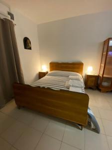 1 dormitorio con 1 cama con cabecero de madera en ZIO PEPPE, en Senise
