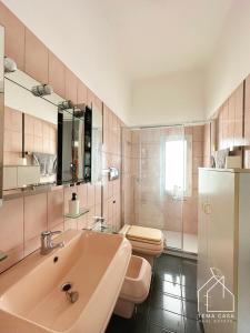 ein rosafarbenes Bad mit einem Waschbecken und einem WC in der Unterkunft CASA DI LUCA - Le Sorelle - A 1 Minuto Dal Centro in Sanremo