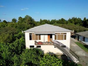 a white house with a bridge and trees at Ani's Green House in Anaklia