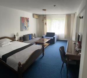 ein Hotelzimmer mit einem Bett und einem Wohnzimmer in der Unterkunft Hotel Rotasar in Sofia