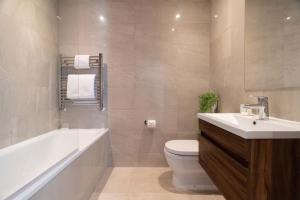y baño con lavabo, aseo y bañera. en Margravine Gardens by Viridian Apartments en Londres