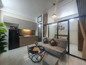 Apartment 59 Phạm Văn Đồng, Hà Nội في هانوي: غرفة معيشة مع أريكة ومطبخ