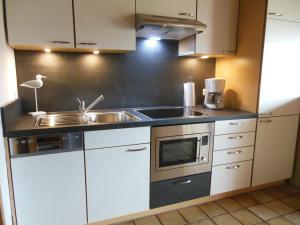 a kitchen with a sink and a stove at Ferienwohnung im Ferienhaus Kästner in Friedrichskoog
