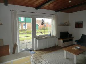 a living room with a large sliding glass door at Ferienwohnung im Ferienhaus Kästner in Friedrichskoog