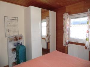 a bedroom with a bed and a window and a refrigerator at Ferienwohnung im Ferienhaus Kästner in Friedrichskoog