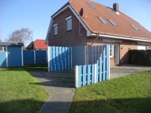 a blue fence in front of a house at Ferienwohnung im Ferienhaus Kästner in Friedrichskoog
