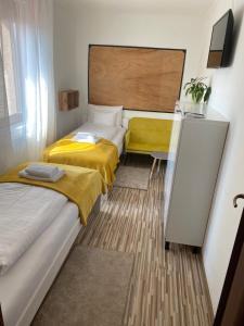 Habitación pequeña con 2 camas y TV. en Just for You, en Nyíregyháza