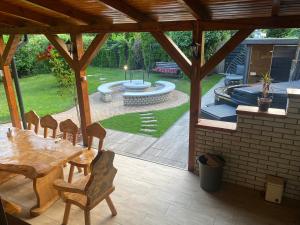 un patio con mesa, sillas y piscina en Just for You, en Nyíregyháza