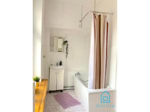 ein Bad mit einer Badewanne und einem Duschvorhang in der Unterkunft Square Room in Danzig