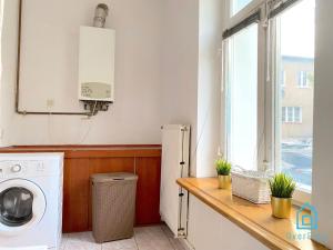 a laundry room with a washing machine and a window at Square Room in Gdańsk