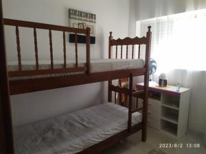 a bedroom with two bunk beds and a desk at Apartamento Turismo 2 quartos em Águas de Lindóia, Natureza!!!! in Águas de Lindoia