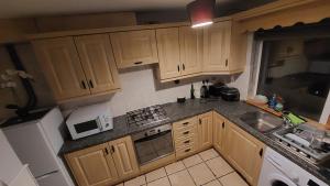 a small kitchen with wooden cabinets and a sink at My Little Home in Letterkenny
