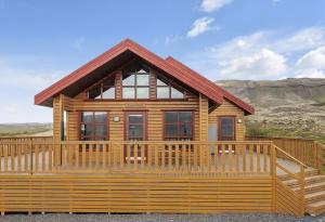 a log cabin with a large wooden deck at The Angels House in Selfoss