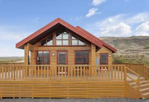 Cabaña de madera con una gran terraza de madera en The Angels House, en Selfoss