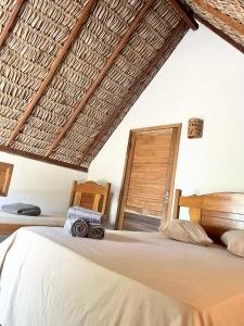 a bedroom with a bed and a wooden chair at Hausatins in Atins