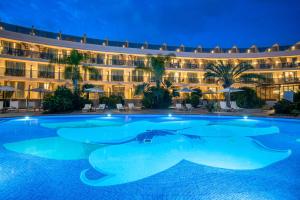 a swimming pool in front of a hotel at night at Sir Anthony in Playa de las Americas