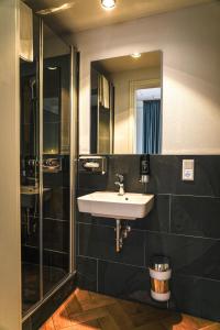 a bathroom with a sink and a shower and a mirror at VillaWie in Rheda-Wiedenbrück