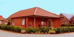une maison en briques rouges avec un toit rouge dans l'établissement Nicky's Ferienhaus, à Geeste