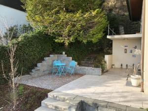 Dos sillas azules sentadas en un patio junto a unas escaleras. en Gästezimmer Erlinsbach bei Aarau, zwischen Aare und Jura, en Niedererlinsbach