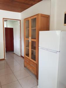 a kitchen with a white refrigerator and a wooden cabinet at F1 studio Martinique in Quartier la Fleury Guiné