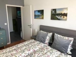ein Schlafzimmer mit einem Bett und zwei Gemälden an der Wand in der Unterkunft Gästezimmer Erlinsbach bei Aarau, zwischen Aare und Jura in Niedererlinsbach