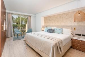 a bedroom with a bed and a table and chairs at Sir Anthony in Playa de las Americas