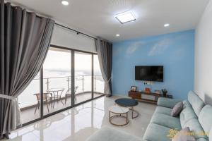 a living room with a couch and a large window at Scenic Country Garden Danga Bay by Lions Bay in Johor Bahru