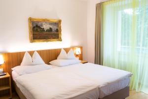 ein Schlafzimmer mit einem großen weißen Bett und einem Fenster in der Unterkunft At the Park Hotel in Baden