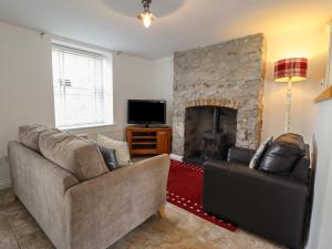 a living room with two couches and a fireplace at Ty Bach Twt in Conwy