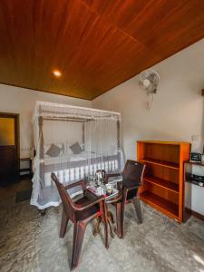 a bedroom with a bed and a table and chairs at Luaya Beach in Tangalle