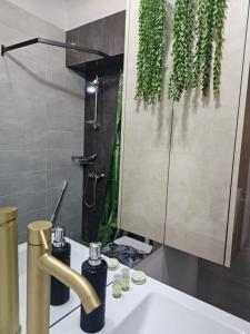łazienka z umywalką i lustrem z roślinami w obiekcie TheLine w Bukareszcie