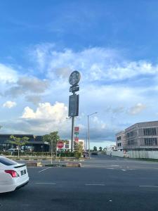 a clock on a pole in the middle of a parking lot at Garden Inns Motel in Kangar