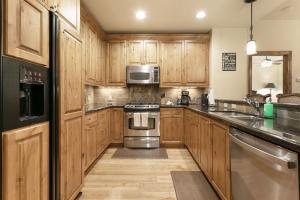 a kitchen with wooden cabinets and stainless steel appliances at B107 Beaver Creek Landing condo in Beaver Creek