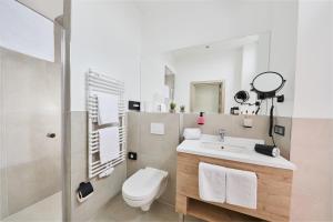 a bathroom with a sink and a toilet and a mirror at Hotel KAISERHOF in Bitterfeld