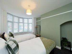 um quarto com 2 camas e uma grande janela em House In Birmingham - Perfect For Contractors - Working Professionals - Driveway - 14 Mins To NEC - 13 Mins to BHX em Birmingham