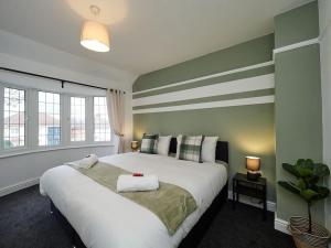 um quarto com uma grande cama branca e 2 janelas em House In Birmingham - Perfect For Contractors - Working Professionals - Driveway - 14 Mins To NEC - 13 Mins to BHX em Birmingham
