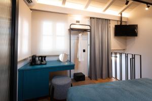 Schlafzimmer mit einem blauen Schreibtisch und einem Bett in der Unterkunft Navria by Aetoma in Nafplio