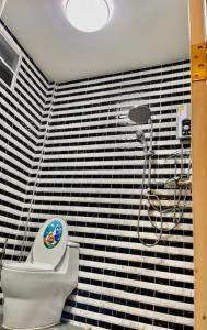 uma casa de banho com um chuveiro e um WC num quarto em บ้านนายหัว ก ชุมพร em Ban Tha Samet (1)